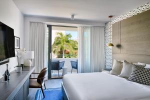 um quarto de hotel com uma cama grande e uma varanda em Kaskades Hotel South Beach em Miami Beach