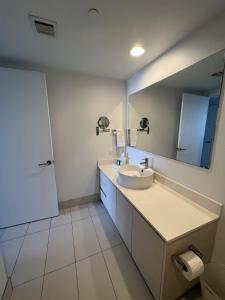 ein Bad mit einem Waschbecken und einem Spiegel in der Unterkunft 23rd floor Luxury & Spacious BeachWalk Resort Apartment with Amazing View in Hallandale Beach