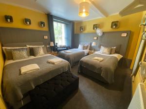 two beds in a room with yellow walls at The Residence - 47 Minto St in Edinburgh