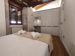 a bedroom with a large white bed with towels on it at Casa Lagarto, (Ribeira Sacra), Taboada in Taboada