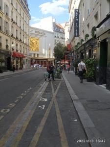an empty city street with people walking down the street at Hotel Geoffroy Marie Opéra in Paris