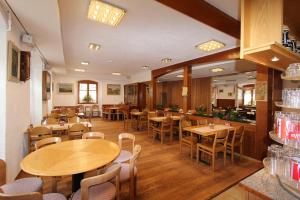 a restaurant with wooden tables and chairs and a bar at Gasthof Adler in Frick