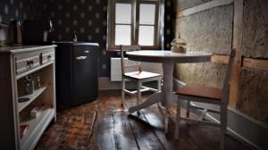 uma cozinha com uma pequena mesa e um frigorífico em In De Swaene em Kortessem