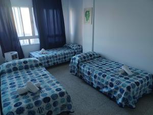 Habitación con 3 camas en una habitación en Malaguetor Home, en Málaga