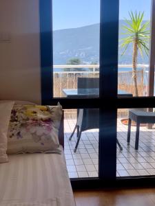 a bedroom with a view of the ocean from a window at Apartments Herceg Novi in Herceg-Novi