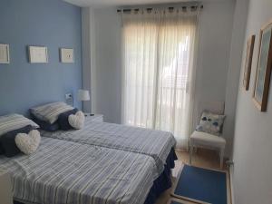 een slaapkamer met 2 bedden en een raam met een stoel bij Los Arqueros Golf lovely condo near Marbella & Puerto Banus in Benahavís