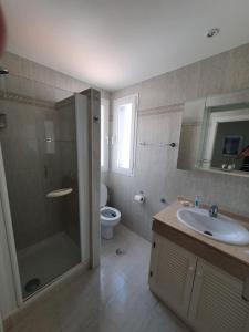 een badkamer met een douche, een wastafel en een toilet bij Los Arqueros Golf lovely condo near Marbella & Puerto Banus in Benahavís