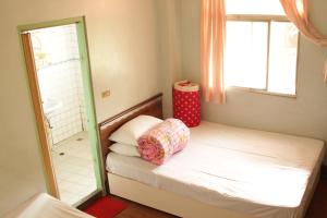 a small bedroom with a bed and a mirror at Ron Gong Hotel in Chiayi City