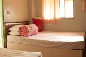 a small bedroom with two beds with a pink pillow at Ron Gong Hotel in Chiayi City