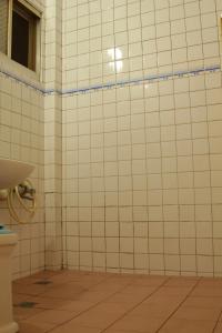 a bathroom with a toilet and a tiled wall at Ron Gong Hotel in Chiayi City