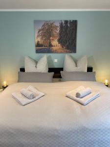 a large white bed with two towels on it at FeWo - Bergblick in Klingenthal