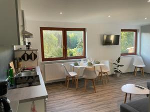 a kitchen and living room with a table and chairs at FeWo - Bergblick in Klingenthal