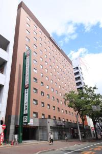 a large building on the corner of a street at Richmond Hotel Hakata Ekimae in Fukuoka