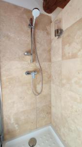 a shower with a shower head in a bathroom at PROCHE UZES LE COCON DU PEINTRE ANGLAIS in Sanilhac-et-Sagriès