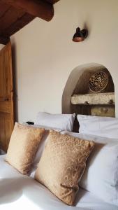 un letto con cuscini bianchi e una lampada; di PROCHE UZES LE COCON DU PEINTRE ANGLAIS a Sanilhac-et-Sagriès