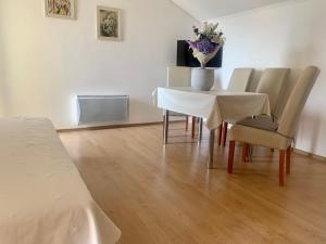ein Esszimmer mit einem Tisch und Stühlen mit einer Blumenvase in der Unterkunft Apartments Herceg Novi in Herceg-Novi