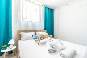 a small bedroom with a bed with blue curtains at Brand New Studio near Downtown in Heraklio