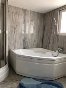 eine weiße Badewanne im Bad mit Fenster in der Unterkunft BluVilla in Malvaglia