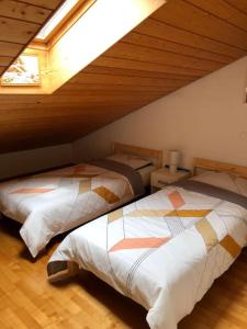 two beds in a room with a attic at BluVilla in Malvaglia