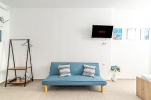 a blue couch in a living room with a tv at Brand New Studio near Downtown in Heraklio
