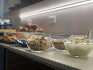 a buffet line with bowls of food on a counter at MAR60 Apartments in Caorle