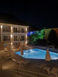 a swimming pool in front of a building at night at 3 Island View Hotel in Nydri