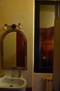 La salle de bains est pourvue d'un lavabo et d'un miroir. dans l'établissement Terme e relax nella campagna viterbese, à Viterbe