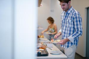 a man standing in a kitchen preparing food at MAR60 Apartments in Caorle