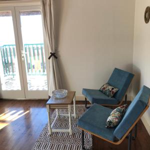 a living room with two chairs and a table at Relais des Combettes in Sutrieu