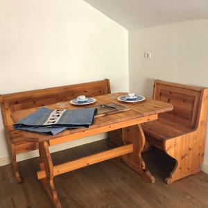 uma mesa de madeira com dois pratos por cima em Relais des Combettes em Sutrieu
