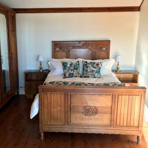 ein Schlafzimmer mit einem Holzbett mit zwei Nachttischen in der Unterkunft Relais des Combettes in Sutrieu