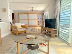 un salon avec une table en verre et une télévision dans l'établissement The View, à Bora Bora