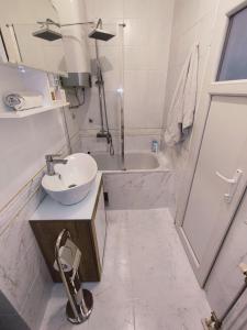 un bagno bianco con lavandino e vasca di Arizona Dream a Novi Sad