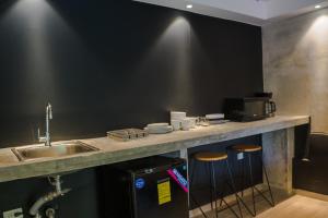 a kitchen with a sink and a counter with stools at Villa Noelia in Saboga