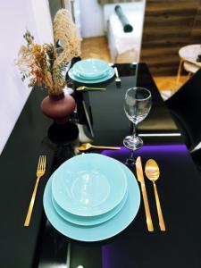 un tavolo nero con piatti blu e argenteria di Arizona Dream a Novi Sad