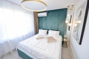 ブカレストにあるOne by One - by Grand Accommodationのベッドルーム1室(青い壁の白いベッド1台付)