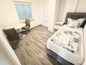 a bedroom with a bed and a table and chairs at FMI33 Next to Airport in Kelsterbach +17 photos