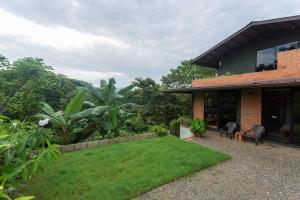 einen Hinterhof eines Hauses mit grünem Rasen in der Unterkunft Casa Melina Torio Cozy upscale 2bd jungle House in Torio