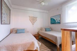 1 dormitorio con 2 camas, ventana y ventilador en Casa Melina Torio Cozy upscale 2bd jungle House, en Torio