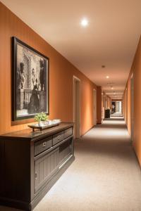 a hallway with orange walls and a large painting on the wall at Turnhout City Hotel in Turnhout