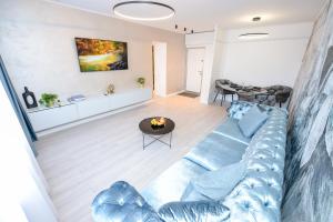 uma sala de estar com um sofá azul e uma mesa em One by One - by Grand Accommodation em Bucareste