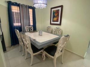 a dining room with a white table and chairs at comfortable 3 bedroom condo with free parking spot building 5 in Los Paredones