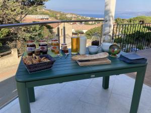 een blauwe tafel met eten en drinken op een balkon bij Casa Santa Giulia in Propriano