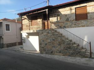 a stone house with a staircase on the side of it at Hara's Apartments in Prinos