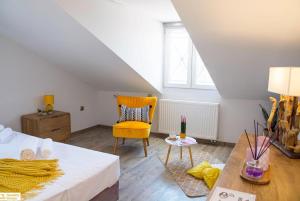 a bedroom with a bed and a yellow chair at Serenity Domus in Lefkímmi