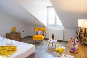 a bedroom with a bed and a yellow chair at Serenity Domus in Lefkimmi