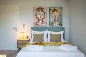 a bedroom with a bed with two paintings on the wall at Serenity Domus in Lefkímmi