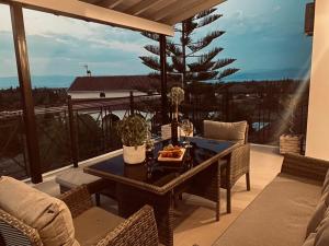 a patio with a table and a tree on a balcony at Serenity Domus in Lefkimmi