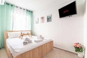a bedroom with a bed with a tv on the wall at Renovated Studio near Downtown in Heraklio