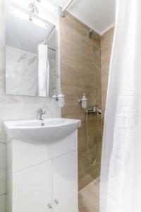 a white bathroom with a sink and a shower at Renovated Studio near Downtown in Heraklio